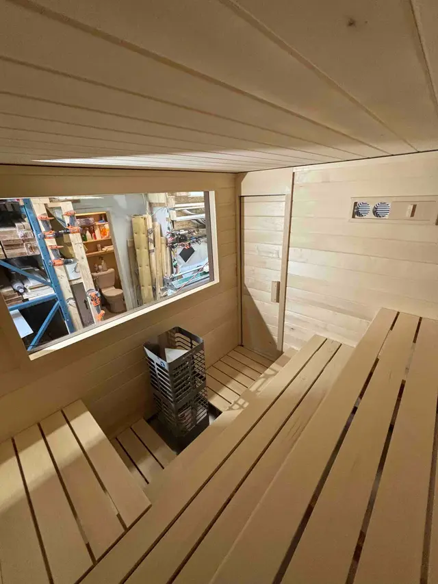 Interior of a 92" x 76" sauna with extra height, a window and benches, in the shop