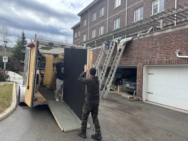 Installers unloading sauna panels from a trailer