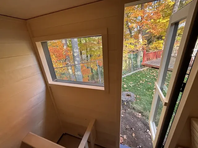Aspen interior with a window onto autumn trees and an open door