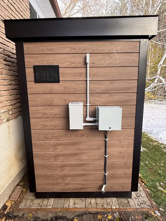 Woodgrain sauna wall with a vent and two electrical boxes