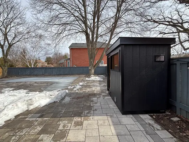 Black sauna on a paver patio in winter