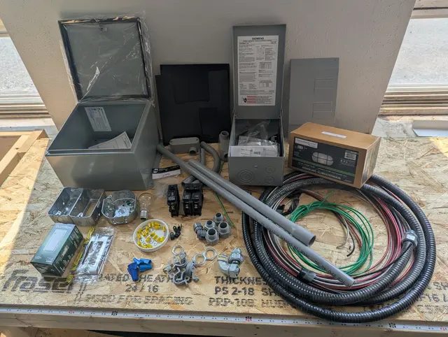 Electrical Option 2 components laid out: sub-panel, breakers, wire and fittings