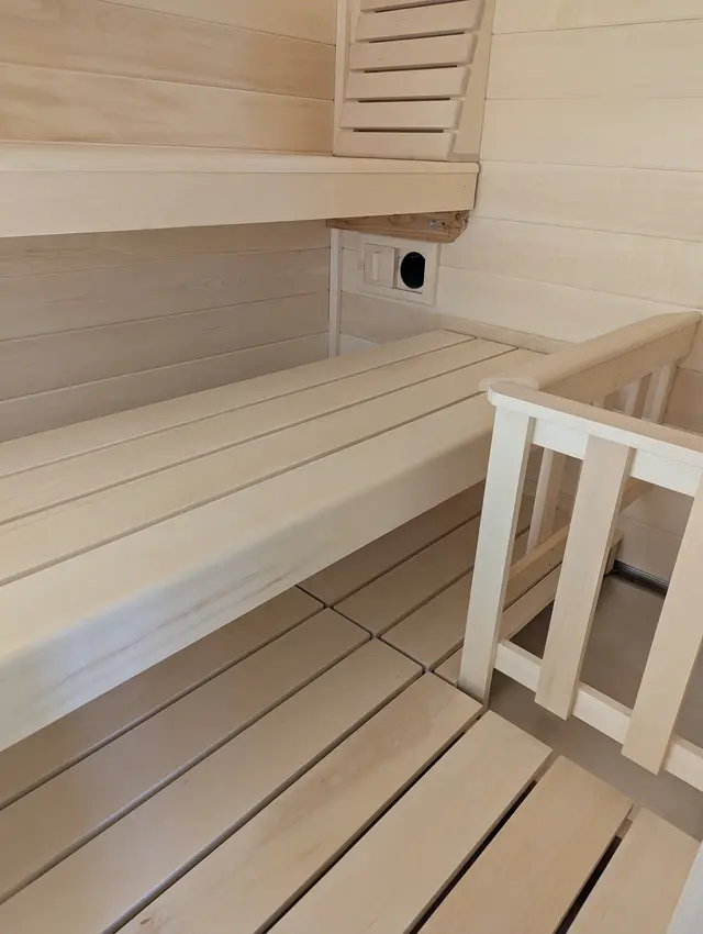 Aspen benches and safety railing inside a sauna