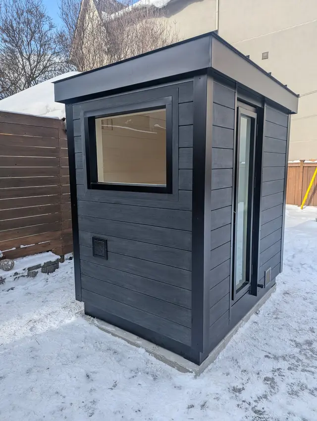 Dark grey sauna with a side window, in the snow