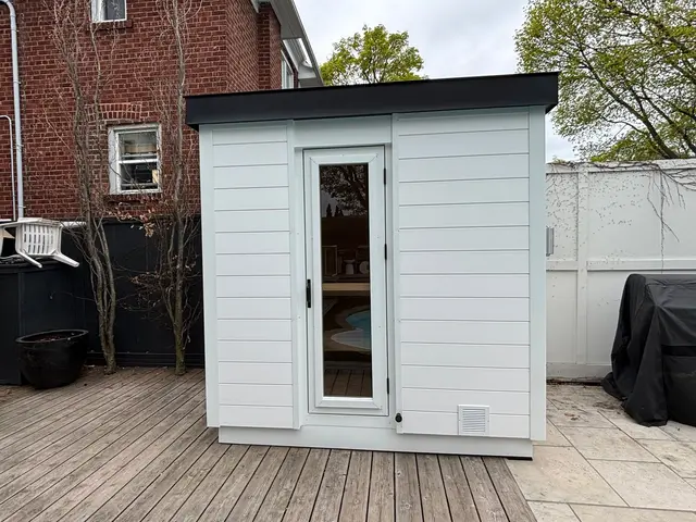 Sauna with Crystal White Chamclad cladding and a glass door on a deck