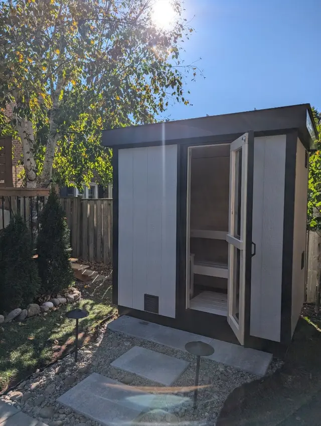 Grey sauna with the door open, at dusk
