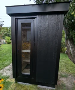 Ryt Saunas' sleek black outdoor sauna with a full-length glass door, offering premium heat retention and comfort. Designed for year-round use in cold climates, this sauna combines modern aesthetics with efficient insulation.