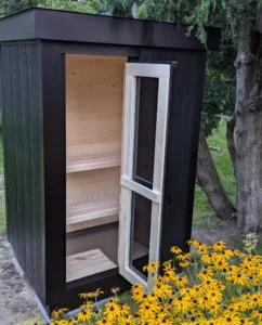 Compact outdoor sauna by Ryt Saunas with a modern black exterior and aspen wood interior. Features a full glass door, providing a luxurious and efficient heat retention solution, ideal for year-round use in cold climates.